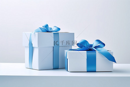 蓝色桌子上的两个礼品盒和一条蓝丝带