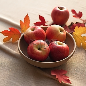 小枫叶背景图片_四个红苹果放在一个小碗里，放在铺满秋叶的桌子上