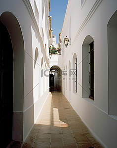 一栋白色墙壁的白色建筑中的一条狭窄通道