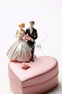 一对新婚夫妇坐在粉红色的心形盒子上