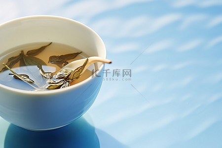 蓝色表面白杯中的茶叶