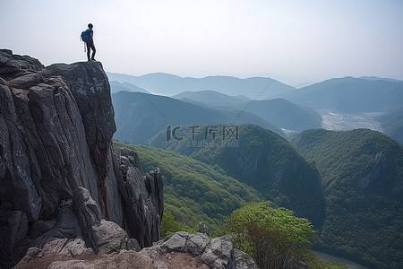大山谷背景图片_一个人走在悬崖边观察山谷