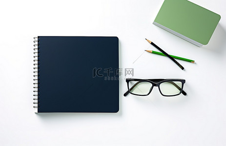 办公用品背景背景图片_黑书的纸眼镜和记事本在白色背景作为背景