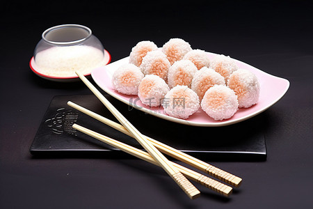 筷子传统背景图片_用筷子将炒饭迷你球放在盘子上