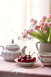 茶壶和一碗樱桃放在桌布上
