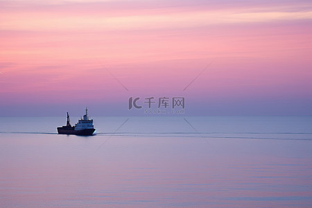 一艘船在海上驶过夕阳