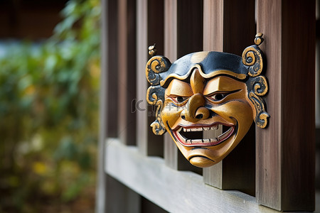 初二回门背景图片_木屋旁的栅栏上有一个亚洲小面具
