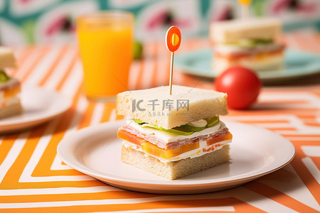 三明治用一根别针固定在盘子上，并用橙色装饰