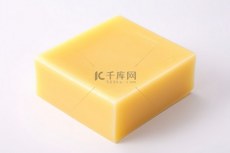 起司背景图片_白色表面上的一块黄色肥皂