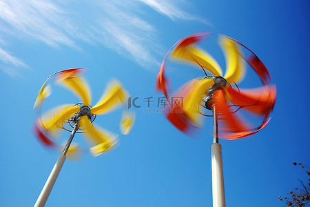 黄色风车背景图片_有红色和黄色叶子的两个风力涡轮机