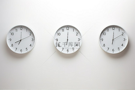 工作室文化墙背景图片_白色墙壁上排成一排的三个白色大钟
