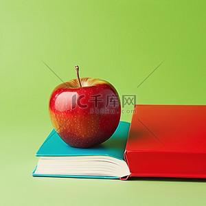 一本打开的书和绿色背景旁边的一个红苹果