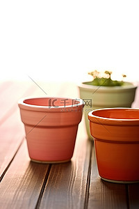粘土盆栽背景图片_木桌上排列着两个不同颜色的粘土花盆