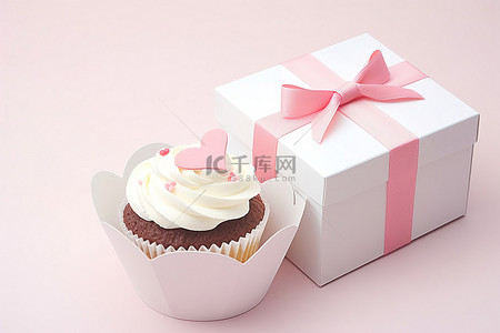 白色纸杯蛋糕背景图片_白色盒子里有两个纸杯蛋糕，上面有粉色蝴蝶结