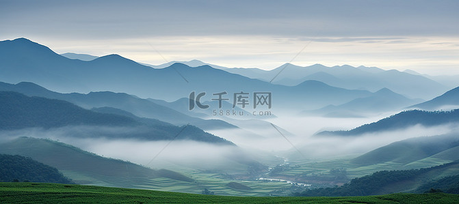 国潮农业背景图片_郁郁葱葱的绿色牧场，山景雾气和云彩