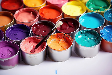 油画刷子背景图片_刷子旁边有多个彩色油漆罐