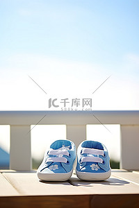 毛主度的袜子背景图片_白色木凳上绣有蓝色袜子的蓝白色婴儿鞋