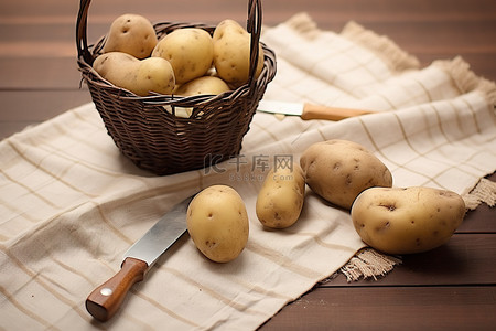 木桌上有篮子的土豆和布上的工具