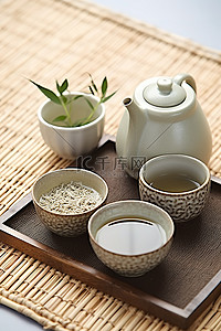 新鲜的茶叶背景图片_竹盘杯和壶上的新鲜茶