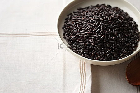 乌龙黑米茶背景图片_布表面白碗中的黑米