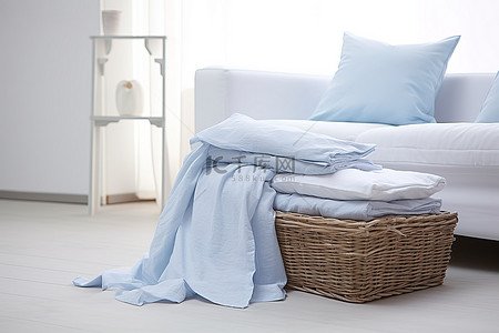 沙堆png背景图片_白色和蓝色的桌布堆放在白色沙发上
