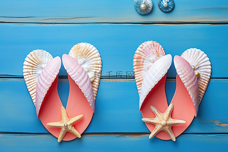 蓝色木质背景上铺着两只带贝壳的粉红色拖鞋