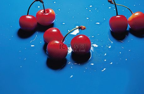 水果蓝水果背景图片_蓝色表面上的红樱桃