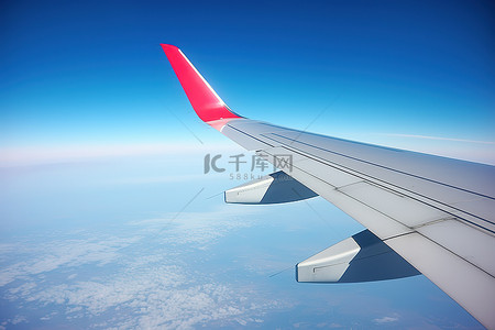 飞机空中背景图片_飞机的机翼飞过蓝天