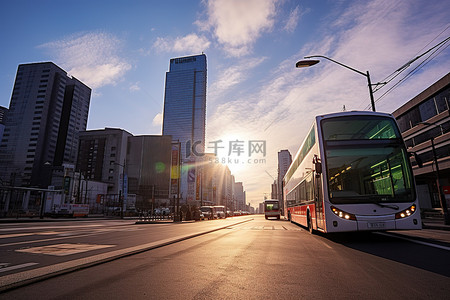 一条城市街道正在看到太阳从一些建筑物和公共汽车上升起