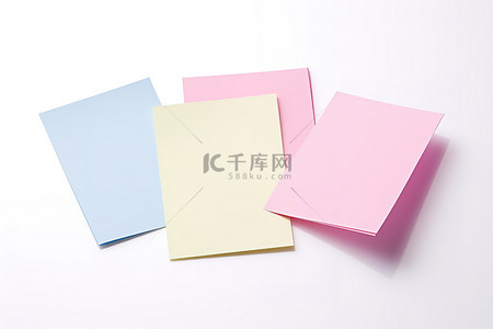 五张粉色蓝色和白色便条卡躺在白色表面上
