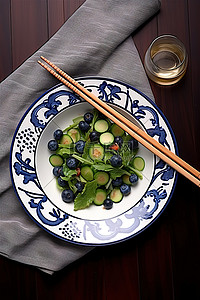 健康水果沙拉背景图片_筷子旁边的白盘上的沙拉