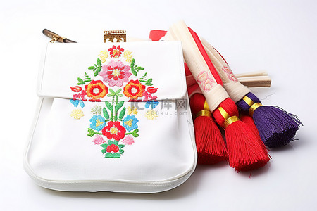 酷奇包包背景图片_红白刺绣围兜和彩色包包