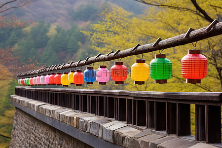 灯笼古建筑背景图片_一座老桥上挂着五颜六色的灯笼，远处有山