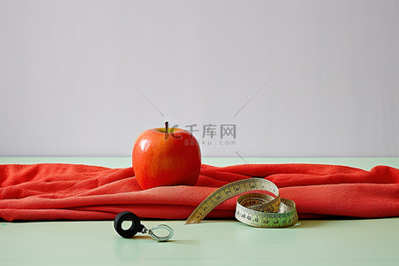 苹果表盘背景图片_苹果和橙子坐在毛巾上的卷尺