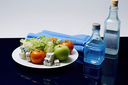 水果沙拉蔬菜奶酪块一瓶水和一条运动毛巾