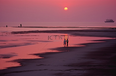 太阳海滩背景图片_黄昏时分，太阳开始落山，两个人在海滩上散步