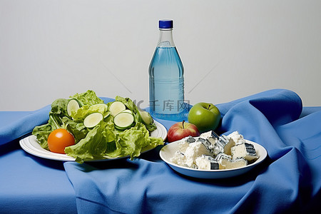 水果沙拉蔬菜奶酪块一瓶水和一条运动毛巾