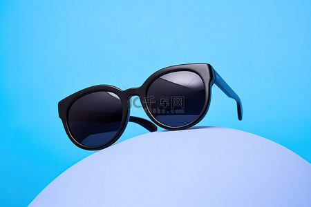 黑色游泳池背景图片_蓝色球上的黑色太阳镜