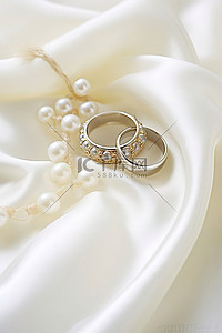 步入婚姻殿堂背景图片_白布上的金色和白色珍珠戒指
