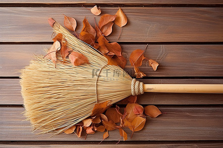 扫地小帮手背景图片_木质背景上有叶子的扫帚