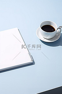 一杯咖啡和笔记本放在蓝色背景的桌子上