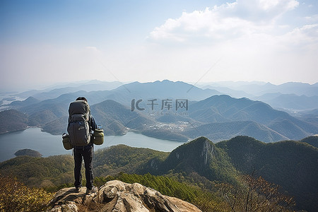 背着背包在山上俯瞰山水的男人