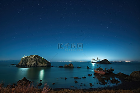 岸上的波妞背景图片_夜间海岸上的一艘船和沉船，天空中有白色和蓝色的星星