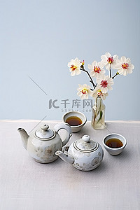 凉茶壶背景图片_背景前桌子上的两个茶壶和鲜花