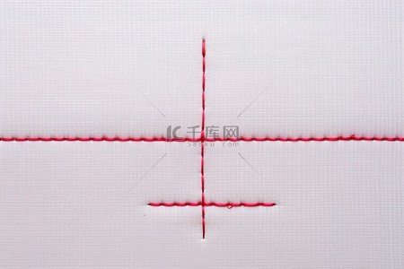 白色正方形末端带有绣花针的红线