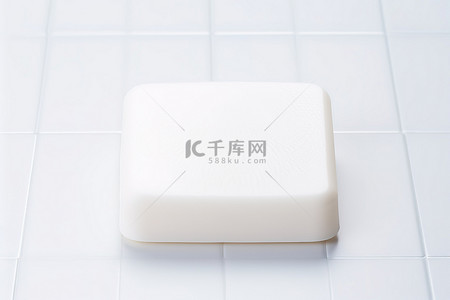白色瓷砖背景上白色小肥皂条的图片