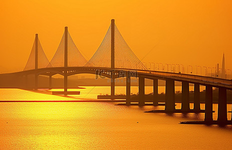 寒假旅行记背景图片_夕阳西下，水面上一座橙色的桥