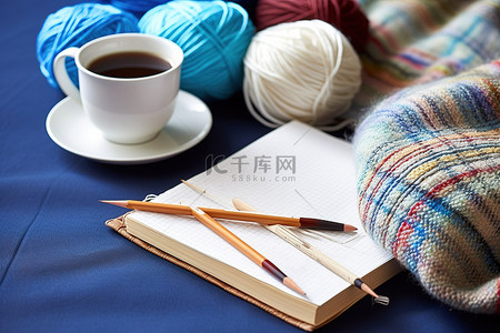彩色纱线和编织别针旁边的一本书