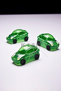 绿色小汽车玩具背景图片_绿色能源三辆写着字的小汽车