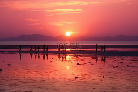 人们站在水面上看夕阳西下